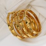 Stainless steel four-leaf clover diamond-studded bracelet for women, high-end flower and heart clasp bangle, light luxury style.
